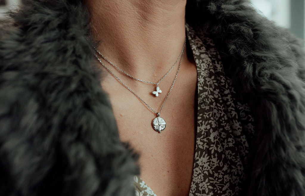 butterfly and medallion silver necklaces worn together